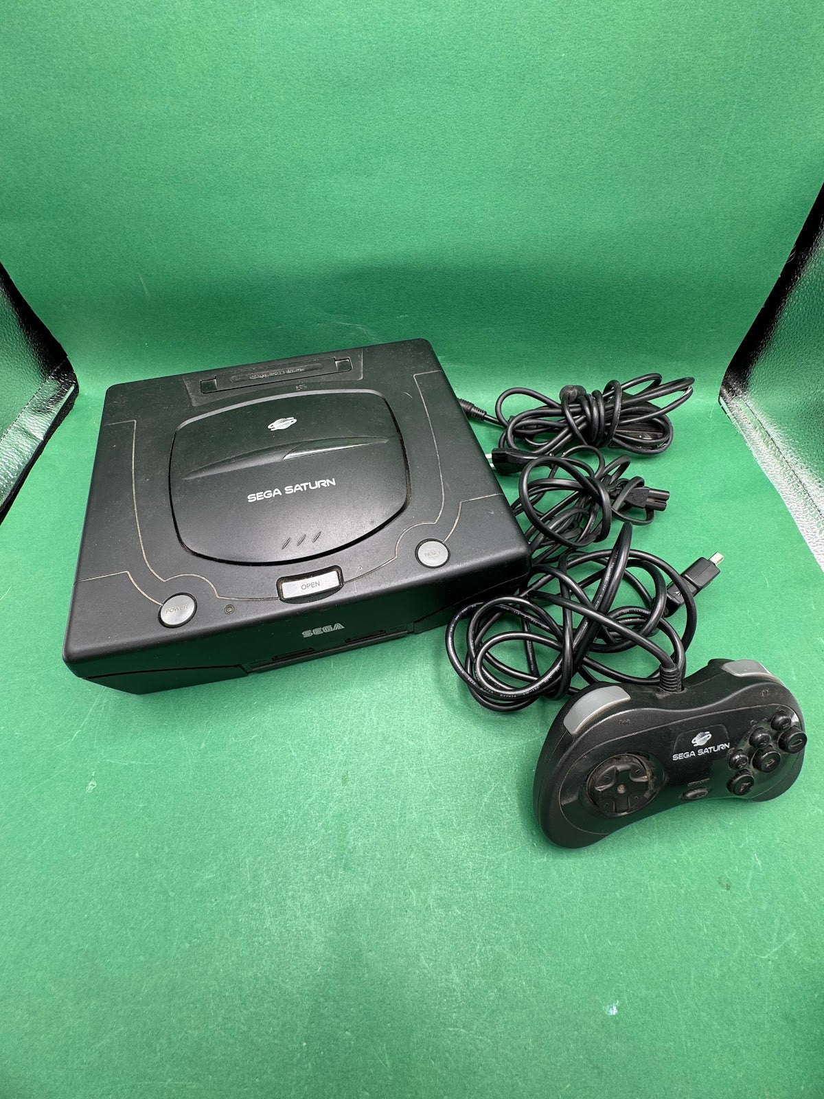Console Sega Saturn nera con controller e cavi