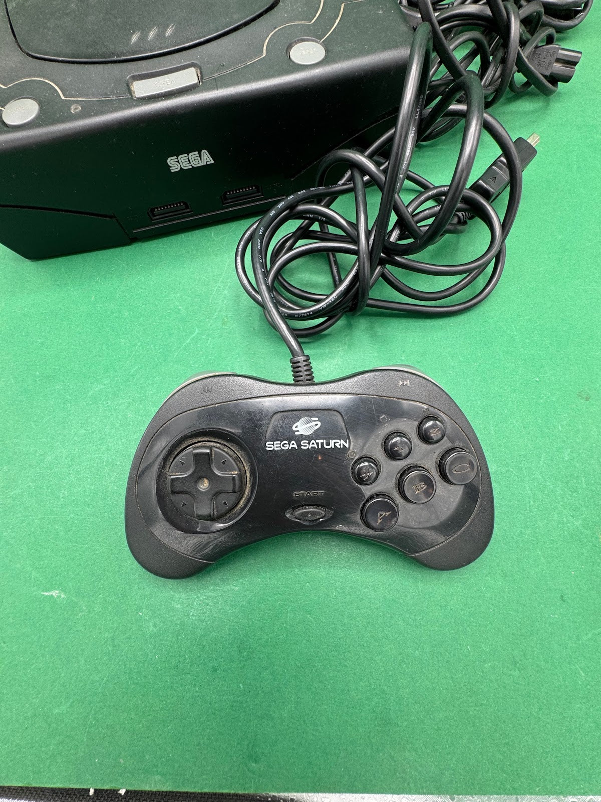 Console Sega Saturn nera con controller e cavi