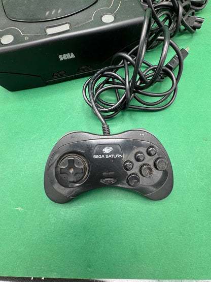 Console Sega Saturn nera con controller e cavi